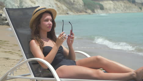 woman sunbathing on the beach in a black bikini