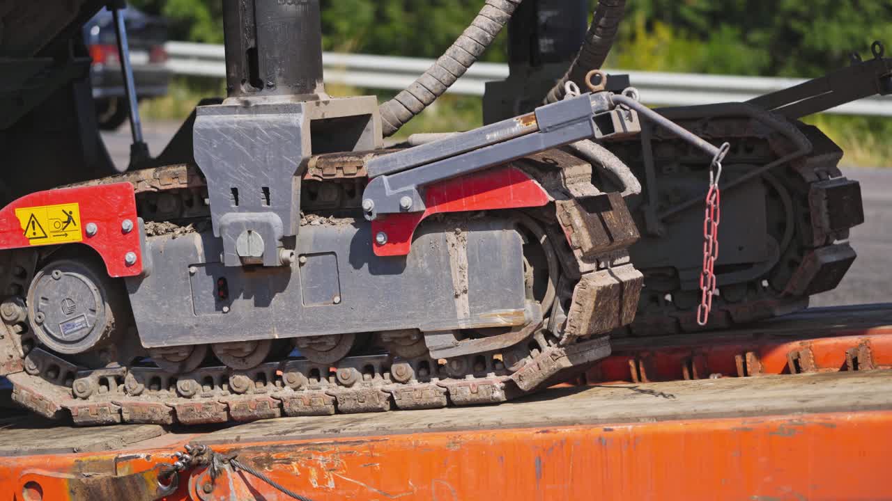Caterpillar excavator in motion. Close-up of a caterpillar crawler machine that moves on metal support. Slow motion.