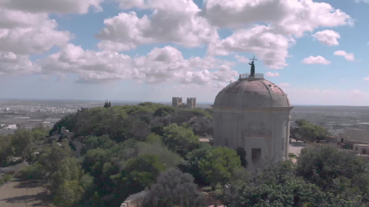 Drone shot revealing a chapel on a hill