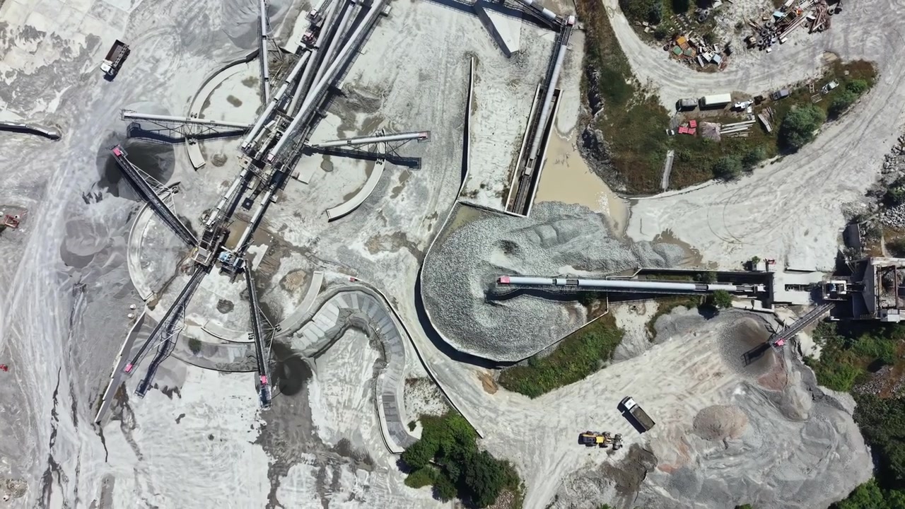 Granite quarry site with machinery and stockpiles showing extraction and processing activities during daylight hours