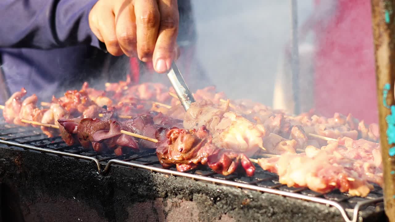 연기가 나는 그릴 불꽃 위에서 개진 고기를 요리하는 것