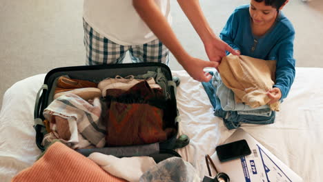 packing, suitcase and son help father for trip