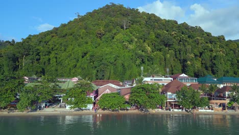 nice aerial top view flight beach village huts resort, tropical bungalows on mountainous island thailand 2022