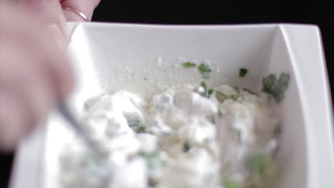 Mixing-a-sour-cream-sauce-with-a-spoon-in-a-bowl