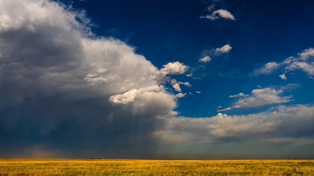 Low angle light shines through storm clouds over colorful fields