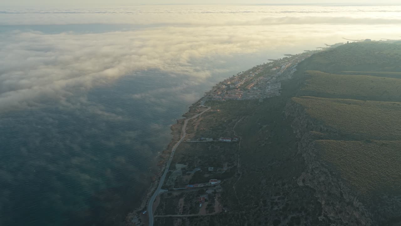 Flygfoto över kusten vid Santa Pola fyr i Spanien ovan molnen