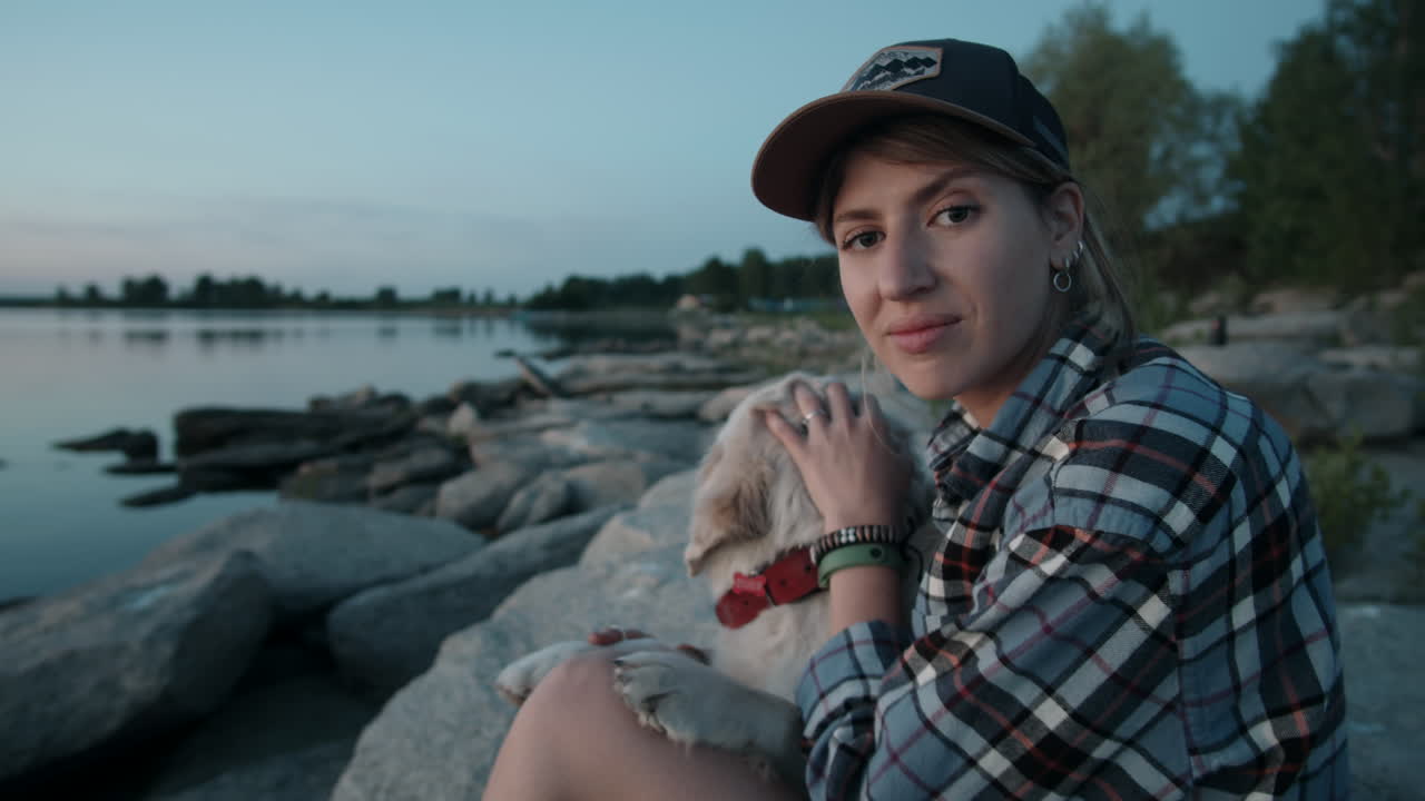 retrato de una mujer feliz con un perro golden retriever junto al lago