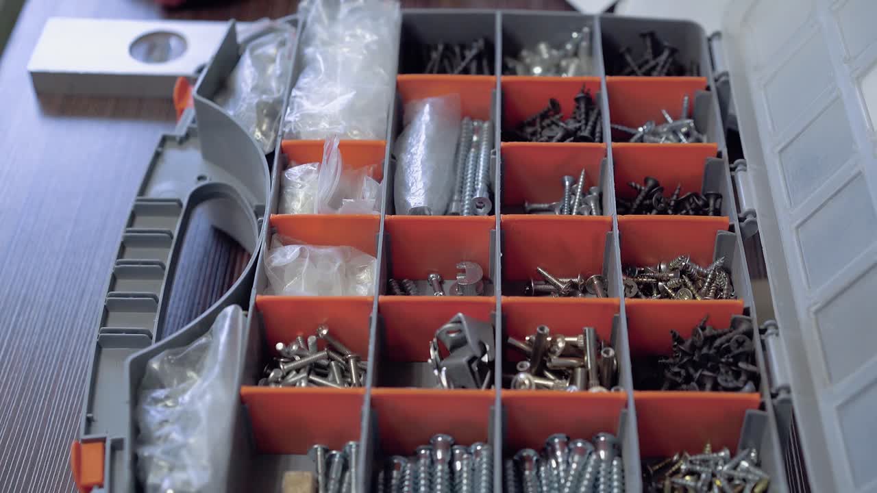 furniture maker takes the necessary bolts from the suitcase Close-up