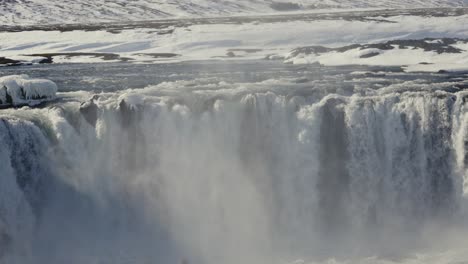 Reveal-shot-of-impressive-Godafoss-waterfall-stream-and-mist-from-basin