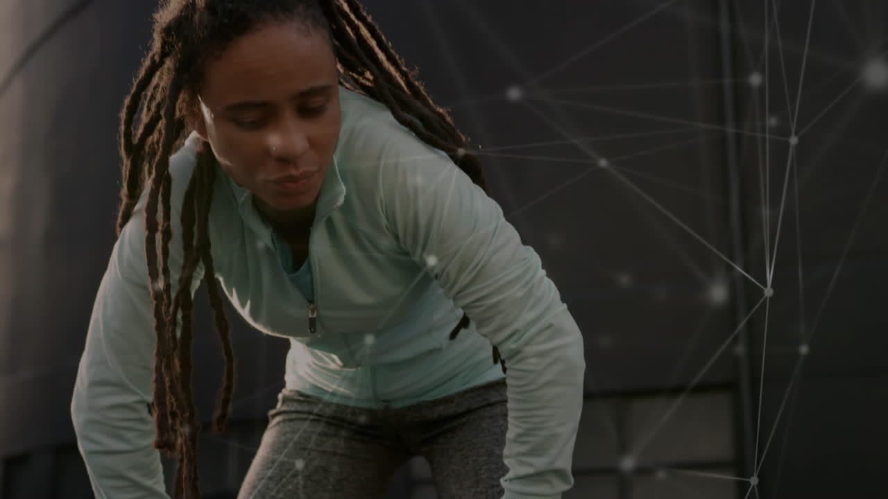 red de conexiones contra la cansada mujer afroamericana en forma que se toma un descanso de correr