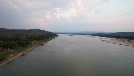 Toma-Aérea-Panorámica-Del-Río-Mekong-En-Una-Mañana-Brumosa-En-El-Distrito-De-Chiang-Khan-En-Tailandia