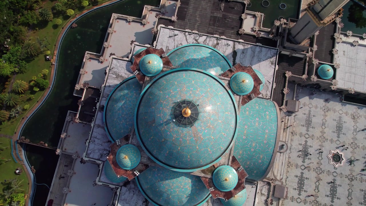 Smooth drone tilt movement over the mosque roof showcasing decorative dome patterns and architectural design.