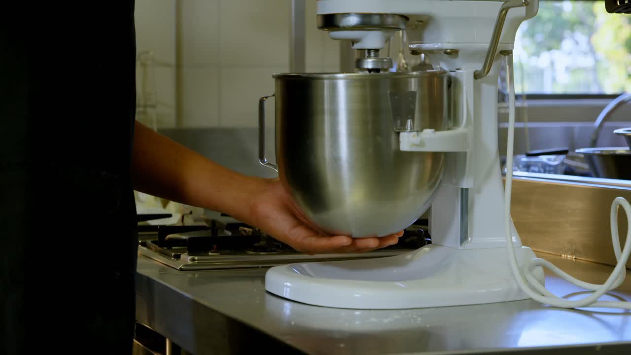 chef usando la máquina de amasar en la cocina 4k