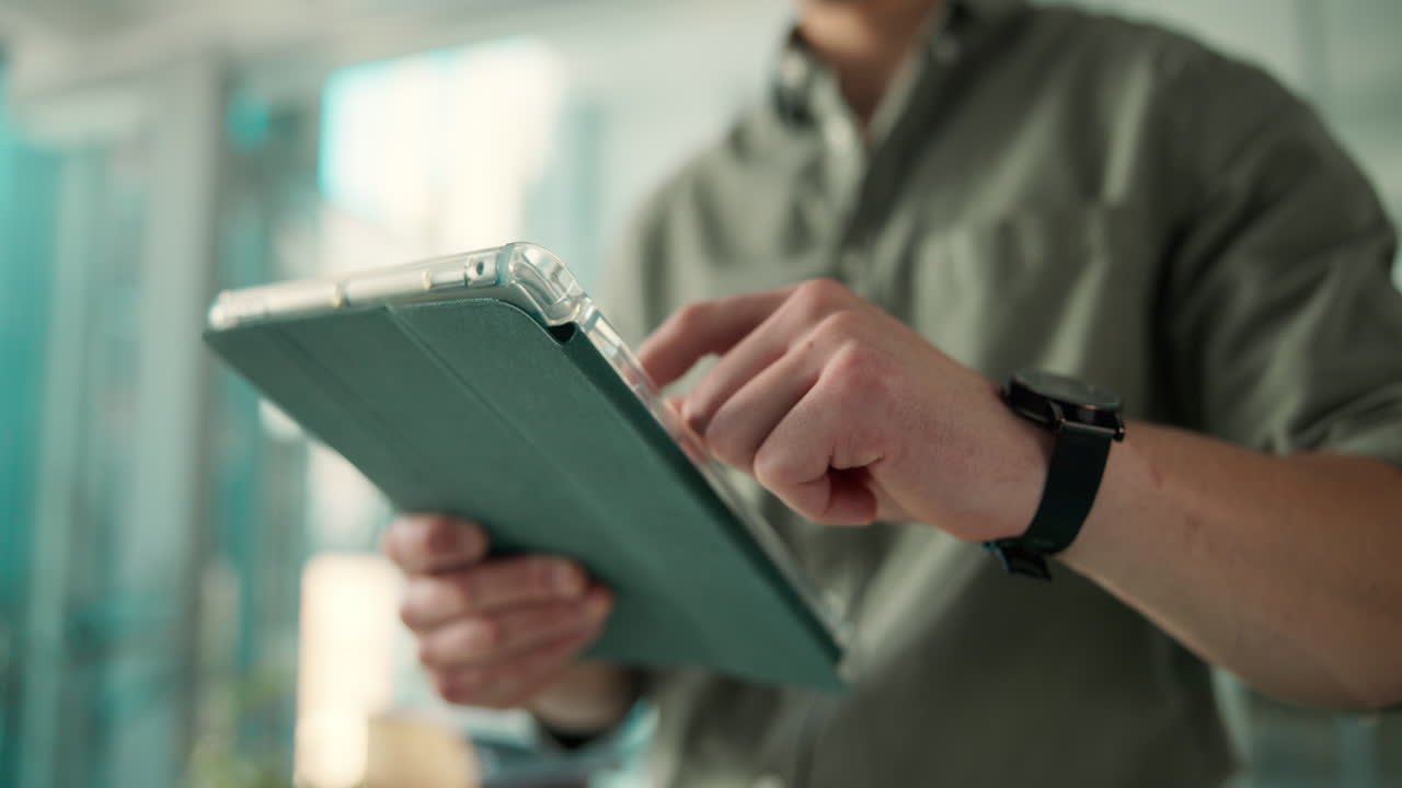 Close-up of Man's Hands Using a Digital Tablet
