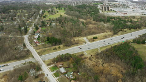 Cars-driving-along-highway-and-overpass-surrounded-by-green-space