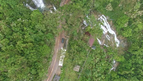 vista superior tomada desde las famosas cataratas tamaraw de mindoro oriental, rodeada de árboles altos y la larga carretera curva en el medio, filipinas