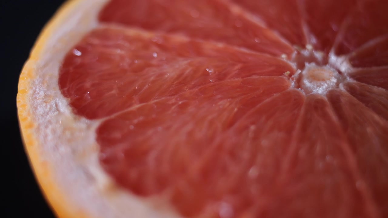 Macro ripresa rotante di 50p della superficie di un pompelmo fresco e biologico