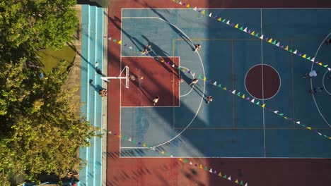 aerial top down of teenager practicing basketball on amateur field in buenos aires during golden hour