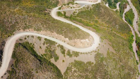 vista aérea de alto ángulo de dos vehículos que recorren un camino sinuoso con curvas