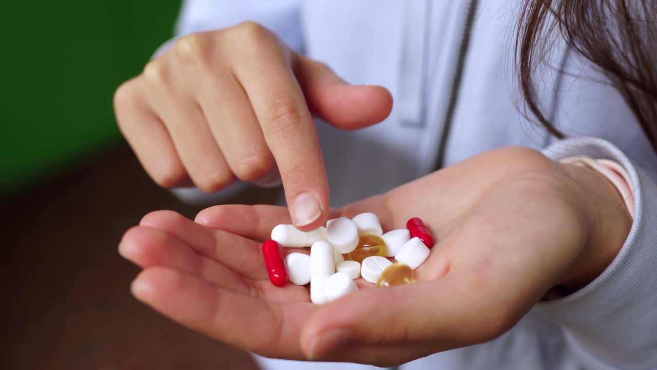 mujer con varias pastillas en la mano