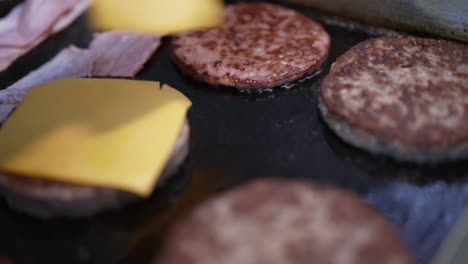 preparing a cheeseburger on a griddle