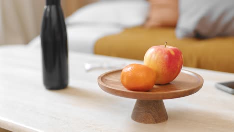 person picks mandarin from modern minimalist table in cozy apartment