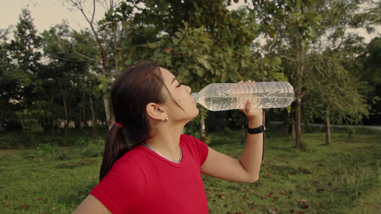mujer bebiendo agua en un parque