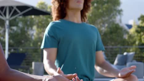 focused diverse friends practicing yoga meditation together sitting in sunny garden, slow motion