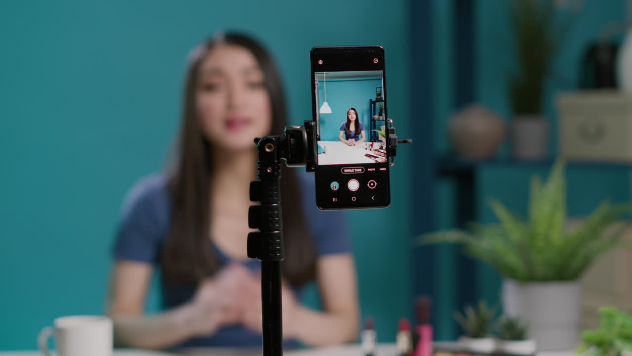 Asian female blogger recording makeup tutorial with broadcast equipment