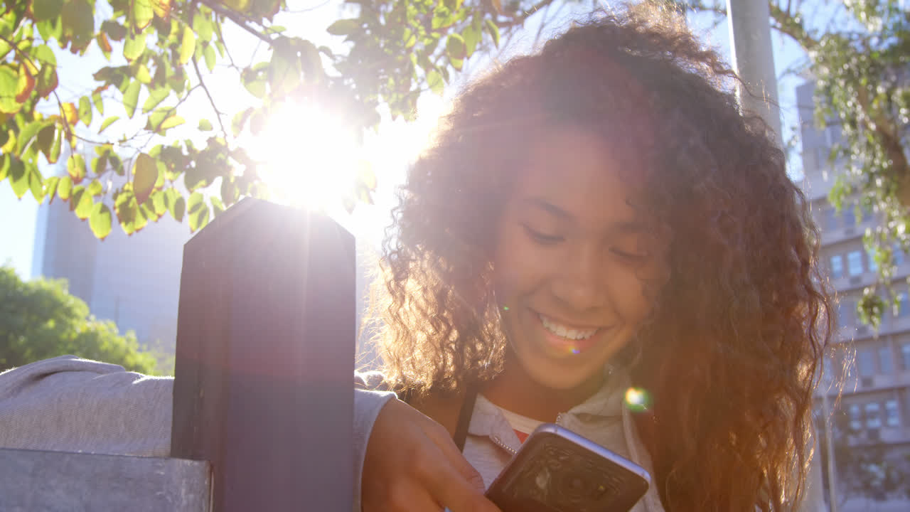Female model using mobile in city street 4k