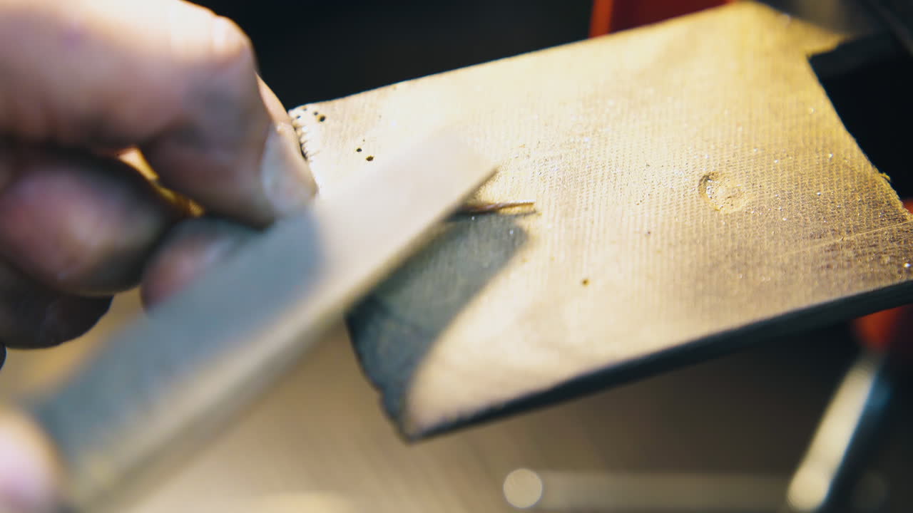 orfebre moliendo el cable con rasp en el lugar de trabajo vista de cerca