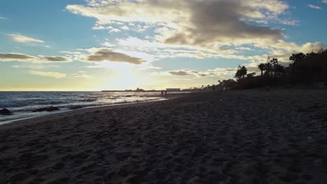 Backwards-dolly-at-the-beach-during-sunset