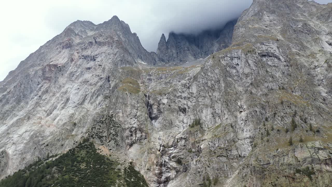impresionantes imágenes de drones de 4k que recorren los picos de alta montaña que revelan un glaciar y cascadas en el lado italiano del mont blanc masivo