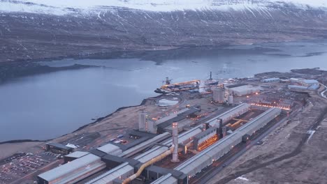 massive industrial facility on fjord shore in east iceland, aerial