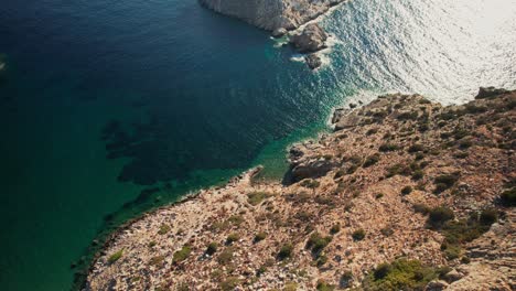 Die-Drohne-Senkt-Sich-Ab-Und-Neigt-Sich-Nach-Oben,-Um-Weißgraue-Felsinseln-Freizulegen,-Die-Die-Bucht-Von-Syros-In-Griechenland-Schützen