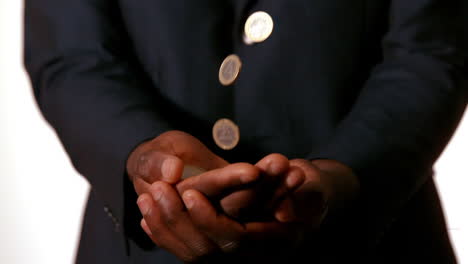 Businessman-catching-falling-coins-in-hands