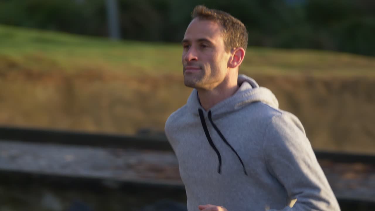 뉴질랜드 오클랜드 해변에서 달리는 청년의 슬로우 모션 클로즈업 샷