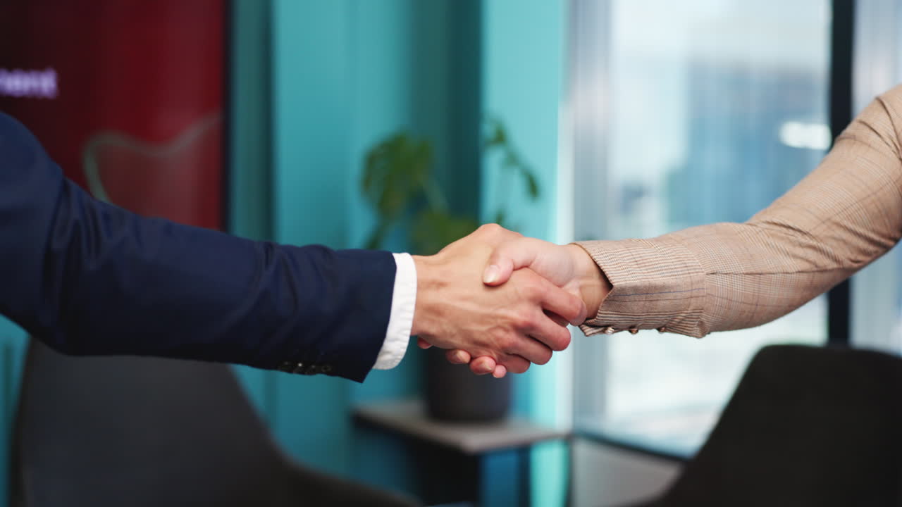 Primo piano di due professionisti che si stringono la mano in un ufficio moderno
