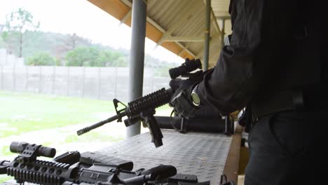 side view of young black military soldier loading rifle during military training 4k