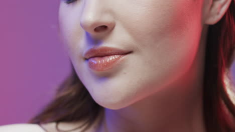 close up of caucasian woman with brown hair and make up touching her face, copy space, slow motion