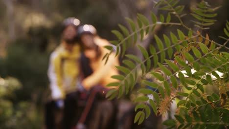 Mountain-biking-couple-sitting-on-a-rock-in-the-forest