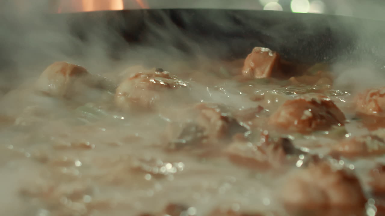 Chicken drumsticks are being cooked on a large skillet