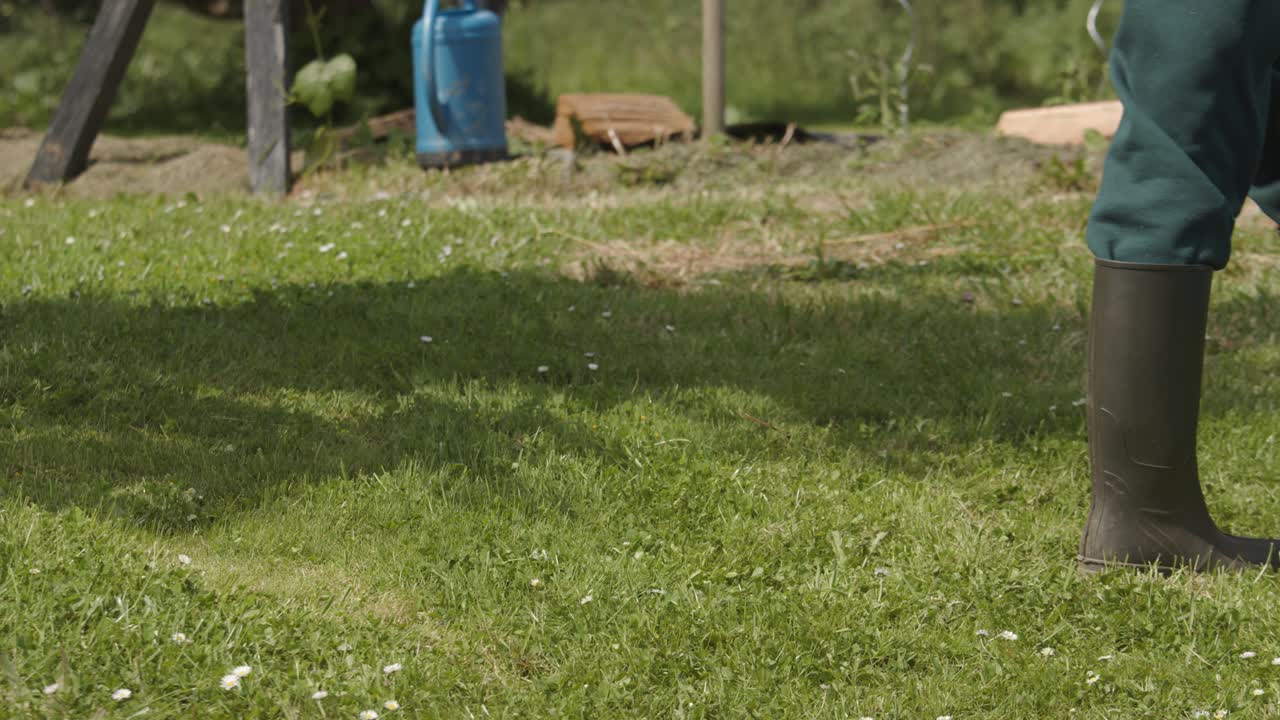 농부 남자가 느린 움직임으로 자신의 개인 정원에서 파란 물을 물을 수 있습니다