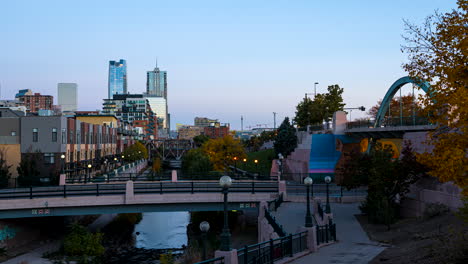 Day-to-night-time-lapse-of-blurred-people-walking-along-the-Cherry-Creek-trail-in-Denver,-Colorado