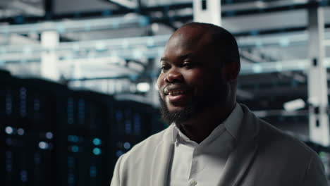 vertical video smiling server room engineer performing maintenance on server racks