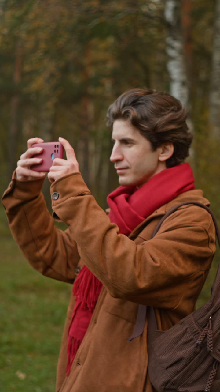 Man taking a picture with his cell phone in the forest