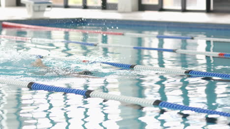 practicing backstroke, person swimming in pool lane