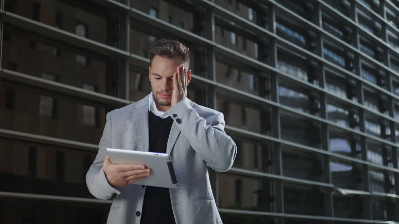 Businessman working on digital tablet at street