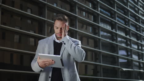 businessman working on digital tablet at street