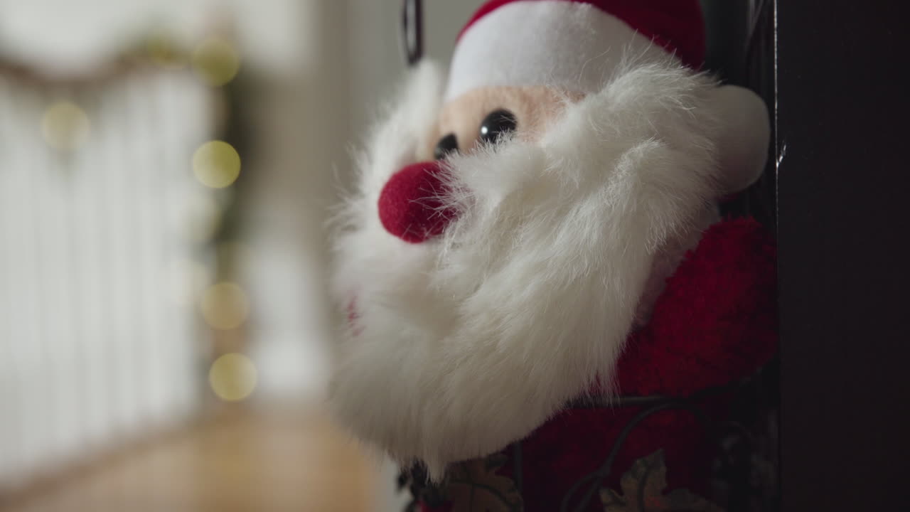 muñeco lento fuera del muñeco de papá noel relleno con guirnaldas y luces navideñas en el fondo